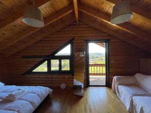 Chalet Klimatia - Όμορφη ξύλινη μεζονέτα με τζάκι的阁楼卧室设有两张床和大窗户