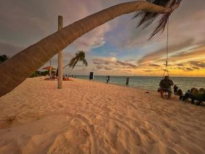 图杜Thoddoo Sunny Beach的一群人坐在海滩上,日落时分