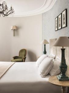 巴黎New Hotel Roblin的卧室配有一张白色的床、一张桌子和一把椅子