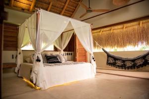 圣菲德安蒂奥基亚Nativa Refugio Escondido的一间卧室配有一张带蚊帐的床