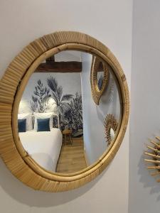马孔Chez Emma et Louise - Maison individuelle avec stationnement的一张圆镜子,床上有床