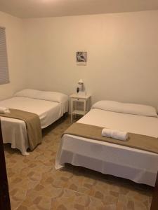 别克斯CRAB ISLAND ADVENTURES APARTMENTS的客房设有两张床和一张带台灯的桌子。