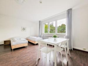 杜伊斯堡RAJ Living - 1 or 3 Room Apartments - 30 Min Messe DUS的配有桌椅和床的房间