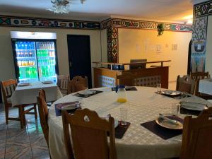 布龙克霍斯茨普雷Sikhula Sonke Guest House的一间用餐室,配有一张带白色桌布的桌子