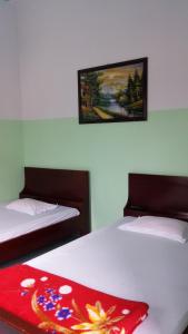 美寿明太酒店的一间卧室配有两张床,床上铺有红色毯子。