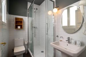 巴塞罗那Casa Gracia Apartments的带淋浴、盥洗盆和镜子的浴室