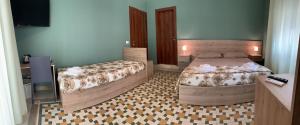 雷焦卡拉布里亚Erythrà Bed and Breakfast的一间卧室配有两张床和电视。