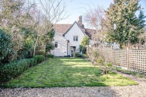 拉文纳姆Rose Cottage in Lavenham的白色房子,有砖墙