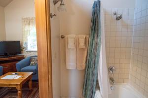 汤森港天鹅酒店的浴室配有浴缸、淋浴和毛巾。