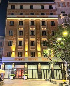 米兰BB Hotels Smarthotel Duomo的一座大型砖砌建筑,晚上有门窗