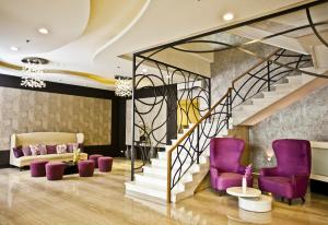 马尼拉The Exchange Regency Residence Hotel Managed by HII的大堂设有紫色椅子和楼梯