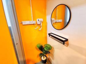 金马仑高原The Cocoon Capsule Hotel的黄色的浴室,带有镜子和植物