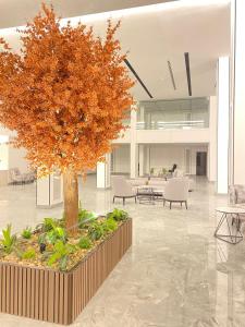 利雅德فندق هوليداي الخليج النجاح的大堂中间的树,有桌椅