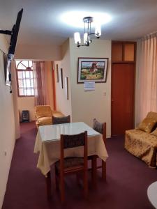 普诺Hostal Vista al Lago Titicaca Puno的客厅配有桌椅和沙发