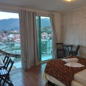 阿蒂巴亚Hospedagem Sol Nascente的一间卧室设有一张床和一个美景阳台