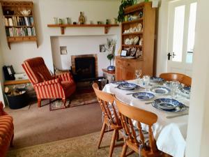 GarrykennedyLackaroe Cottage的一间带桌椅和壁炉的用餐室