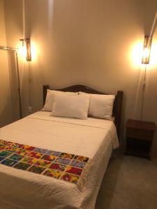 皮廷布Pousada Vila Lua Bela的一间卧室配有一张带两个灯的床