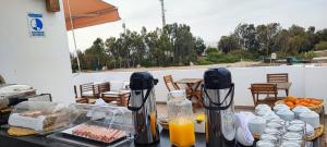 帕拉卡斯Paracas Guest House的露台上的桌子上摆放着食物和橙汁