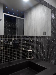 科森扎Manu's Guest Suite的浴室设有黑色水槽和镜子