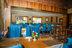 索纳马格Arco Hotels & Resorts sonamarg的餐厅内带蓝色椅子和桌子的用餐室