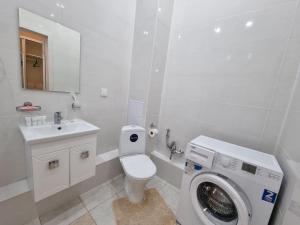 阿斯塔纳1 комнатная рядом c EXPO, Mega Silk Way的白色的浴室内配有洗衣机。