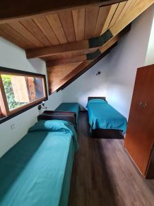 罗萨里奥La casa de Hostal del Sol的客房设有两张床和窗户。