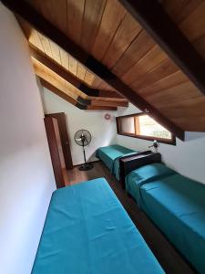 罗萨里奥La casa de Hostal del Sol的客房设有两张绿色的床和窗户。