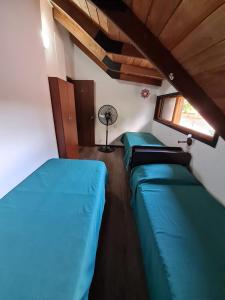 罗萨里奥La casa de Hostal del Sol的带3张床的客房设有窗户和风扇。