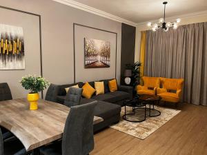 迪拜GOODWOOD SUITES HOMES VACATION的客厅配有沙发和桌子