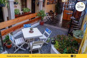 危地马拉安地瓜Posada de San Carlos La Calzada的庭院配有桌椅和植物