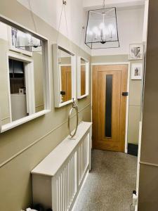 诺里奇City Apartment, 2 min walk to Norwich centre.的一间带盥洗盆和镜子的走廊的房间