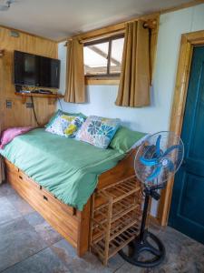 安加罗阿Uka O Te Ra´a Cabaña full equipada.的小型客房配有风扇和一张床。