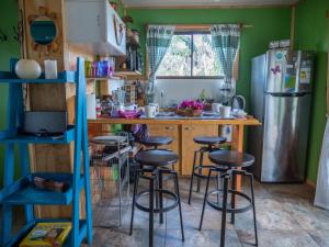 安加罗阿Uka O Te Ra´a Cabaña full equipada.的厨房配有带凳子的柜台和冰箱。