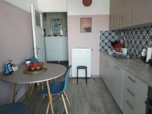 雅典Athens view apartment near Metro station Agia Marina的厨房配有桌椅和水槽。