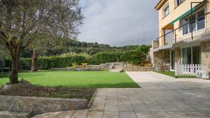 滨海阿雷尼斯Holidays en Arenys de Mar y Montaña的房屋前带绿色草坪的院子
