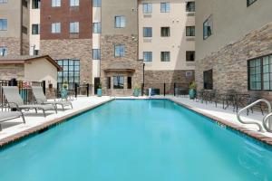 舍尔茨Staybridge Suites - San Antonio - Schertz, an IHG Hotel的一座带椅子的游泳池以及一座建筑