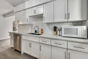 卡尔加里Roxboro #1 Premium Central 3BR Home Parking, Wifi的白色的厨房配有白色橱柜和电器