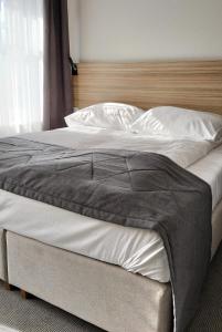 比亚韦斯托克Centrum Apartamenty Jurowiecka 60 parking的一张配有白色床单和木制床头板的大床