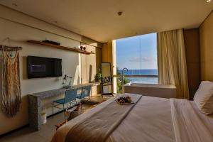萨尔瓦多赞克托克酒店的一间卧室设有一张大床,享有海景