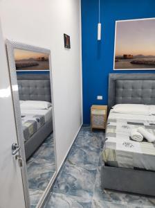 那不勒斯Attico Central Station Napoli的一间卧室配有两张床和镜子