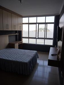 圣维森特岛Lar de férias的一间卧室设有一张床和一个大窗户