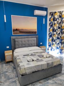 那不勒斯Attico Central Station Napoli的一间卧室配有一张蓝色墙壁的床