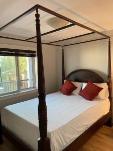 苏克Sooke Vacation suite的一间卧室配有一张带红色枕头的天蓬床