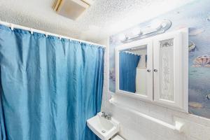 大西洋滩Shorely Suite的浴室设有蓝色的浴帘和水槽