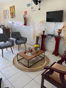德尔米鲁戈韦亚Bom Sossego Pousada DG的客厅配有椅子、桌子和电视