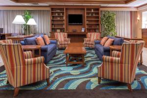 马纳萨斯马纳萨斯温德姆花园酒店的客厅配有沙发、椅子和桌子