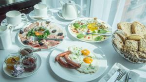 波兹南Andersia Hotel & Spa Poznan, a member of Radisson Individuals的一张白色的桌子,上面有早餐盘
