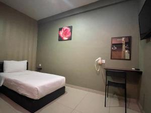 科塔达曼萨拉Parc Hotel Pelangi Damansara的卧室配有一张床,墙上挂着粉红色玫瑰