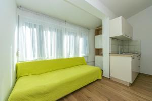 德朗西斯Apartments by the sea Drasnice, Makarska - 6652的窗户房间里一张黄色的沙发