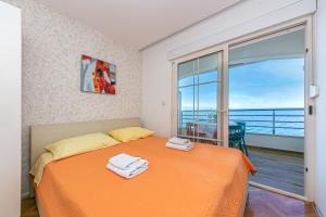 德朗西斯Apartments by the sea Drasnice, Makarska - 6652的一间带橙色床的卧室和一个阳台